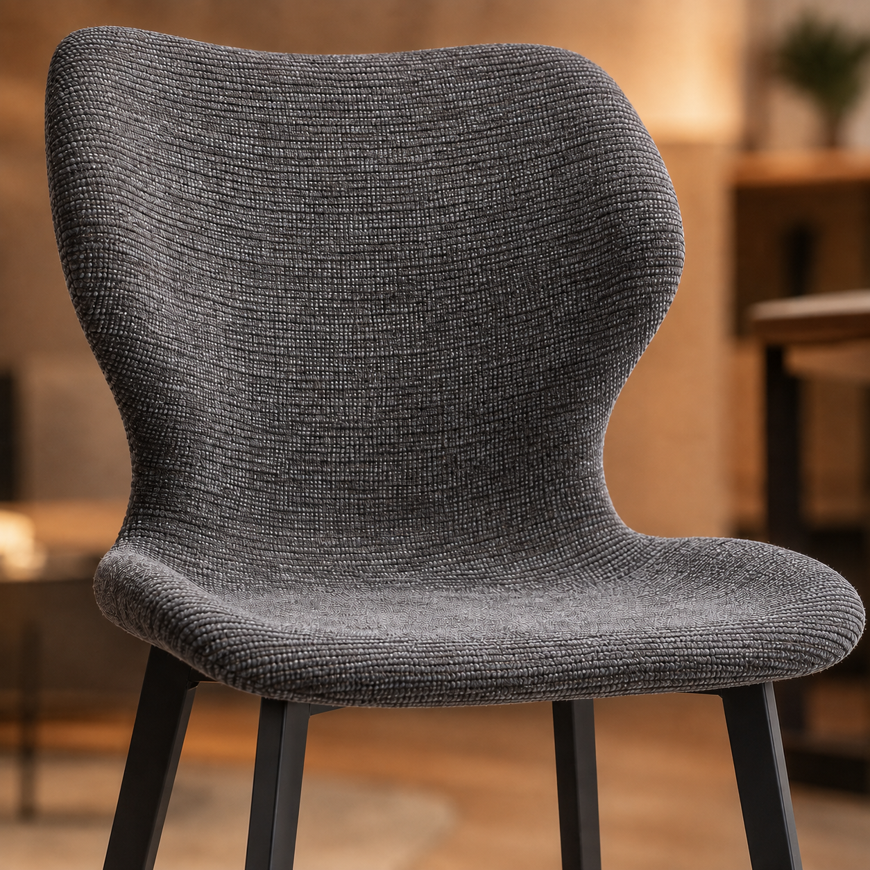 Silla tapizada de diseño moderno con respaldo envolvente y patas metálicas